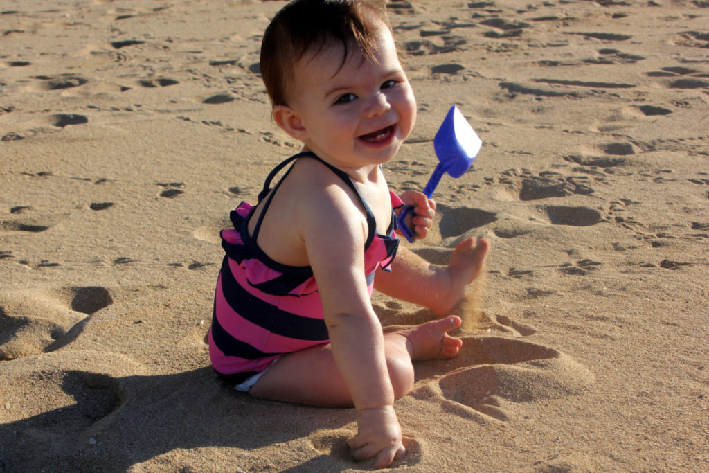 baby plays in the sand at Ko'olina beach on Oahu, Hawaii